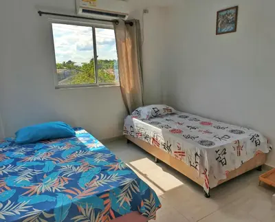 two beds in a room with a window at Apartamento sereno, cerca al mar in El Porvenir