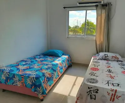 a bedroom with two beds and a window at Apartamento sereno, cerca al mar in El Porvenir