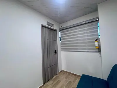 a room with a door and a blue couch at Hospedaje Casa Rueda in Barranquilla