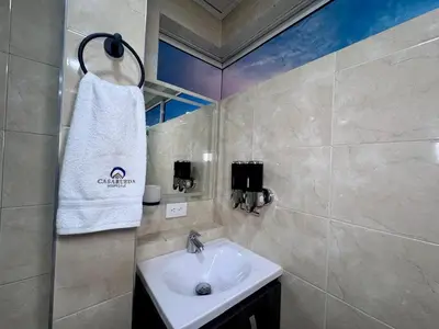 a bathroom with a sink and a towel on the wall at Hospedaje Casa Rueda in Barranquilla