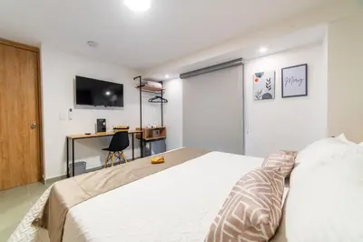 a bedroom with a bed with a television and a desk at Casa Gracia Hotel Boutique in Cartagena de Indias