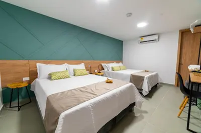 a bedroom with two beds and a blue wall at Casa Gracia Hotel Boutique in Cartagena de Indias