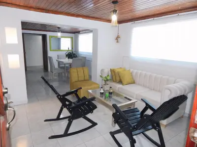 a living room with black chairs and a white couch at Apartment Nurita Boston in Barranquilla