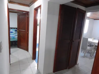 a hallway with two doors and a room with a table at Apartment Nurita Boston in Barranquilla
