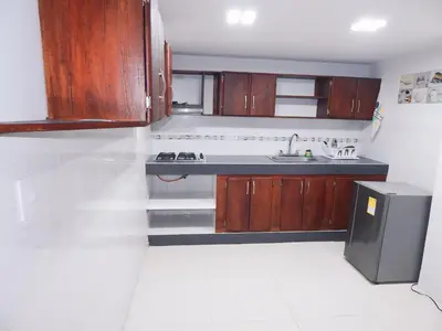 a kitchen with wooden cabinets and a sink at Apartment Nurita Boston in Barranquilla