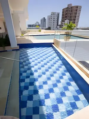 a swimming pool on the roof of a building with blue and white tiles at Modern 2BR next to the Walled City+Oceanside View in Cartagena de Indias