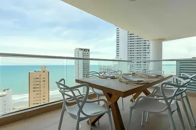 a dining room with a table and chairs and a large window at Modern 2BR next to the Walled City+Oceanside View in Cartagena de Indias