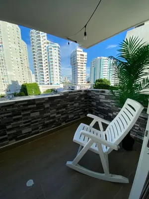 a white bench on a balcony with a view of buildings at LIVING CARTAGENA Apto de lujo in Cartagena de Indias