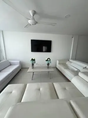 a living room with two white couches and a tv at Gloria Al Laguito Duplex in Cartagena de Indias