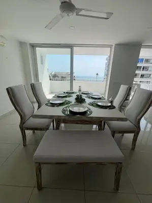 a dining room table and chairs with a view of the ocean at Gloria Al Laguito Duplex in Cartagena de Indias