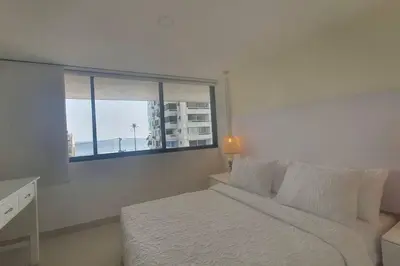 a bedroom with a bed and a large window at Gloria Al Laguito Duplex in Cartagena de Indias