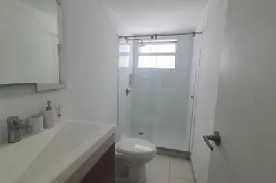a white bathroom with a shower and a toilet at Gloria Al Laguito Duplex in Cartagena de Indias