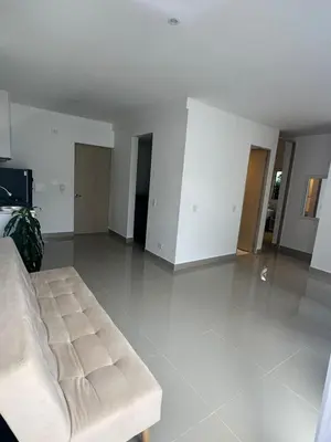 a living room with a couch and a room with white walls at Apartamentos Cartagena Acuarium in Cartagena de Indias