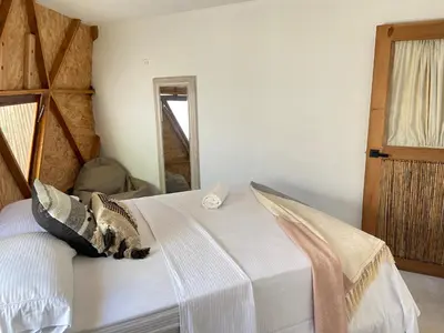 a bedroom with a white bed with pillows on it at Casa de playa Kommox Beach in Cartagena de Indias