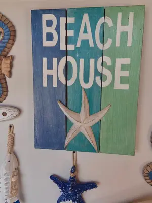 a sign that reads beach huddle hanging on a wall at Casa de playa Kommox Beach in Cartagena de Indias