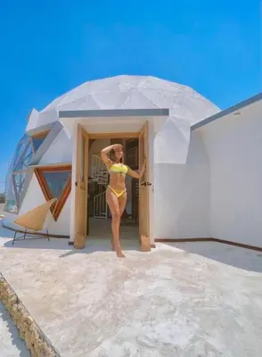a woman in a yellow bikini standing outside of a building at Casa de playa Kommox Beach in Cartagena de Indias