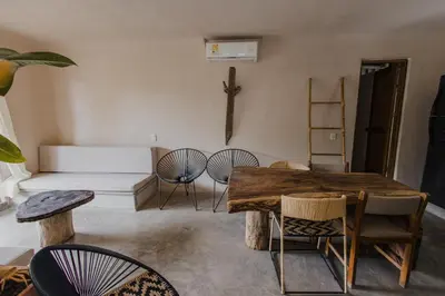 a living room with a table and chairs and a cross on the wall at Apartamento Atlantic 111 in La Perdiz