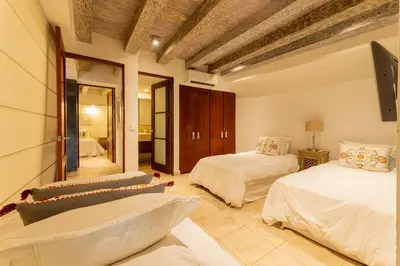 a bedroom with two beds and a mirror at Luxury Colonial Home at Virrey Eslava in Cartagena de Indias