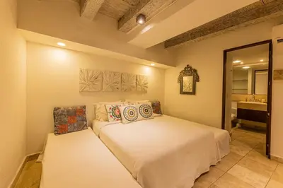 a bedroom with a bed and a bathroom with a sink at Luxury Colonial Home at Virrey Eslava in Cartagena de Indias