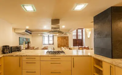 a large kitchen with yellow cabinets and a stove at Luxury Colonial Home at Virrey Eslava in Cartagena de Indias