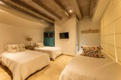 a room with two beds and a tv in it at Luxury Colonial Home at Virrey Eslava in Cartagena de Indias