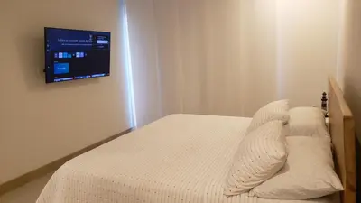 a bedroom with a bed with a tv on the wall at Apartamento Cartagena in Cartagena de Indias