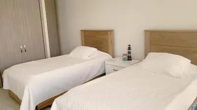 two beds in a bedroom with white sheets at Apartamento Cartagena in Cartagena de Indias