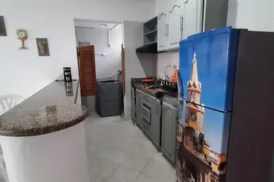 a kitchen with a refrigerator and a counter in it at Cómodo Ap Frente al mar, cerca a la murallas in Cartagena de Indias