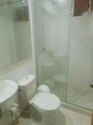 a white bathroom with a toilet and a shower at apartamento Amazilia en alameda del rio in Barranquilla