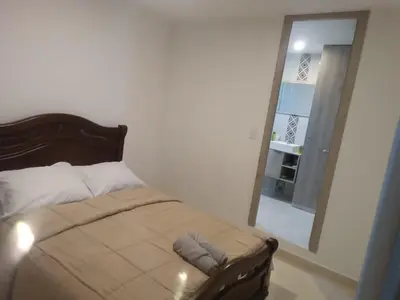 a bedroom with a bed and a mirror and a door at apartamento Amazilia en alameda del rio in Barranquilla