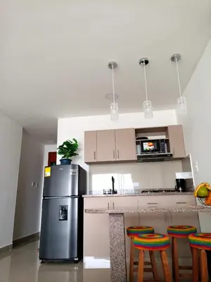a kitchen with a refrigerator and some bar stools at Cartagena Aparta Suite con Vista al Mar in Cartagena de Indias