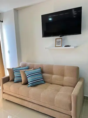 a brown couch with blue pillows in a living room at Cartagena Aparta Suite con Vista al Mar in Cartagena de Indias
