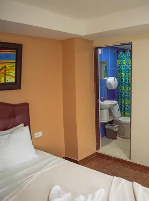 a bedroom with a bed and a bathroom with a toilet at Hotel Boquilla Suites By GEH Suites in Cartagena de Indias