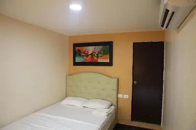 a small bedroom with a bed and a picture on the wall at Hotel Boquilla Suites By GEH Suites in Cartagena de Indias