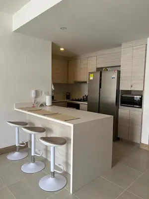 a kitchen with a counter with stools and a refrigerator at Apartamento en Cartagena in Cartagena de Indias