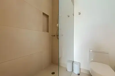 a bathroom with a toilet and a glass shower at Lujoso A Estrenar/Oasis Laguna Cristalina 2BR in Los Arrayanes