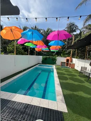 a group of umbrellas on a fence next to a swimming pool at Cabaña salgar - la casa de la playa in Puerto Salgar