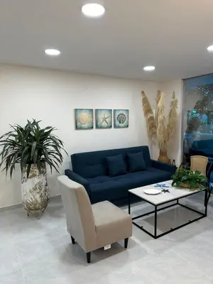 a living room with a blue couch and a table at Cabaña salgar - la casa de la playa in Puerto Salgar