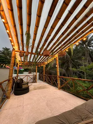 a wooden pergola with lights on a patio at Cabaña salgar - la casa de la playa in Puerto Salgar