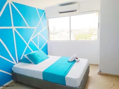 a bedroom with a bed with a blue wall at apto con vista al mar piso 11- in Cartagena de Indias