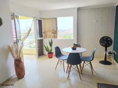 a dining room with a table and chairs and a window at apto con vista al mar piso 11- in Cartagena de Indias