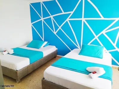 two beds in a room with blue walls at apto con vista al mar piso 11- in Cartagena de Indias