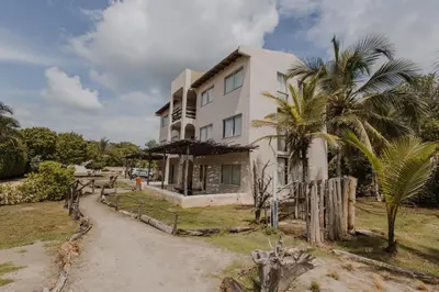a white house with a palm tree in front of it at Apartamento Atlantic 112 in La Perdiz
