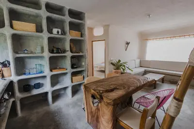 a living room with a table and a stone wall at Apartamento Atlantic 211 in La Perdiz