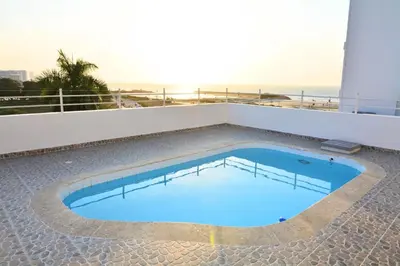 a swimming pool on top of a building with the beach at Te la mereces, frente al mar in Cartagena de Indias