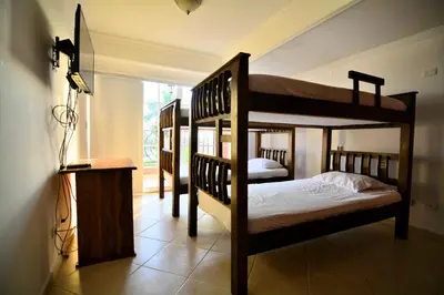 a bedroom with three bunk beds and a television at Te la mereces, frente al mar in Cartagena de Indias