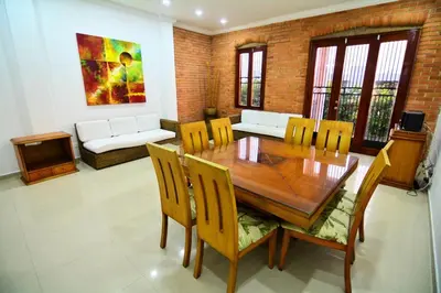 a dining room with a wooden table and chairs at Te la mereces, frente al mar in Cartagena de Indias