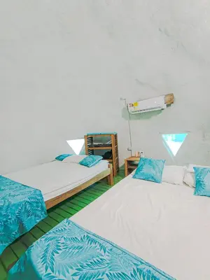 a room with two beds with blue and white sheets at Barracuda Glamping in Paso Nuevo