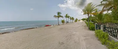 a sandy beach with palm trees and a car on it at Apartamento Atlantic 311 in La Perdiz