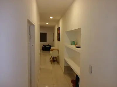 a hallway with a white wall and a room with a table at Casa Marbella in Cartagena de Indias